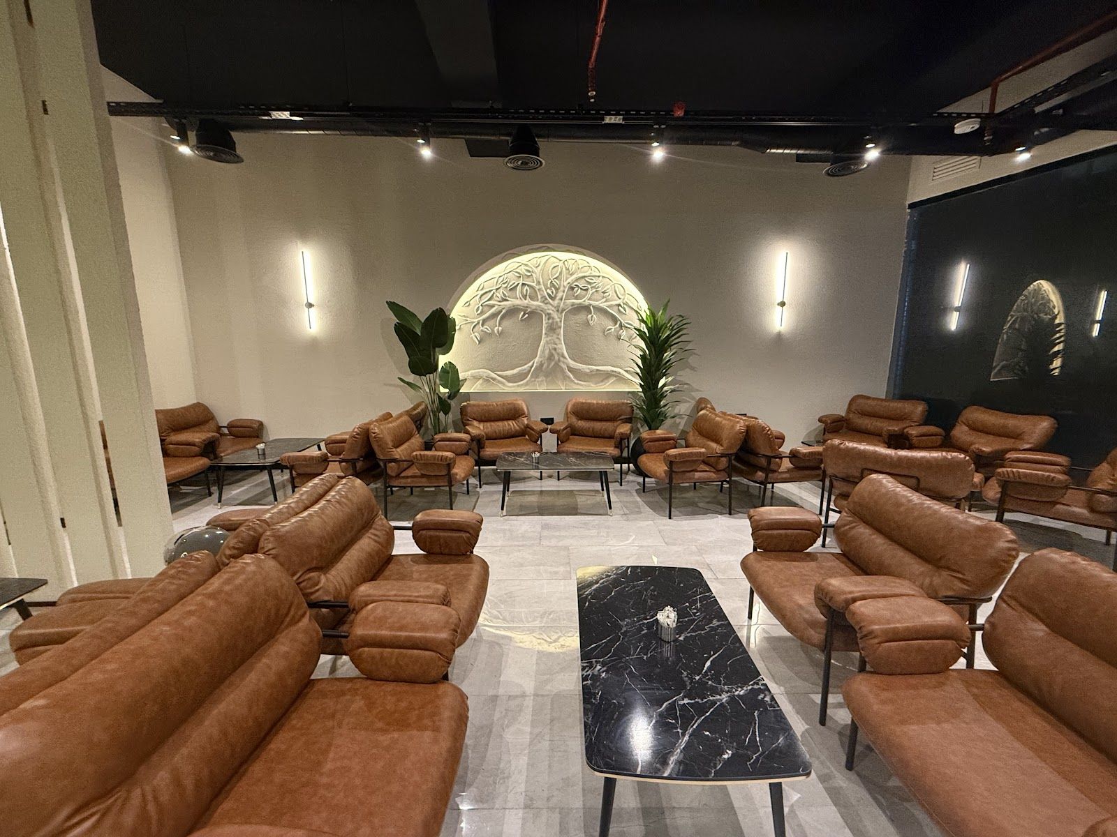 Bueno Lounge salonu, ağaç rölyefli duvar ve deri koltuklar